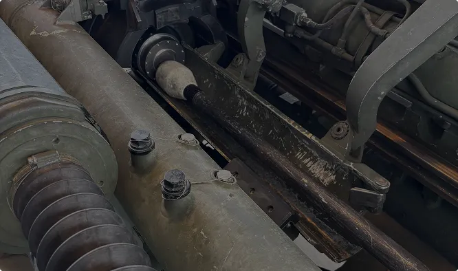 A close-up of a heavy artillery recoil mechanism.