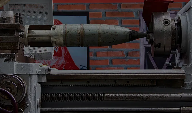 An artillery shell being machined on a lathe.
